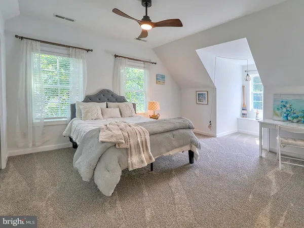 a bedroom with a bed lamp and a large window