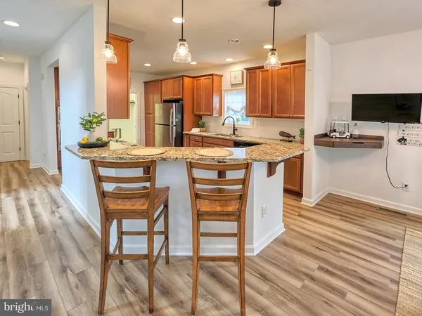 a kitchen with stainless steel appliances a stove a sink dishwasher and a refrigerator with wooden floor