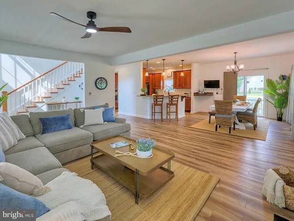 a living room with furniture wooden floor and dining table