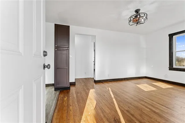 a view of a room with wooden floor and window