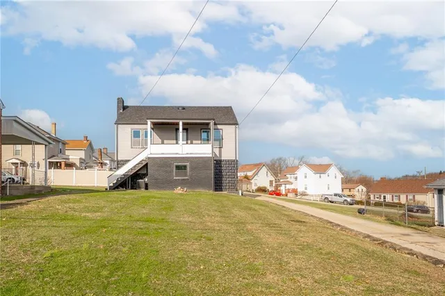 a view of a house with a big yard and a large tree