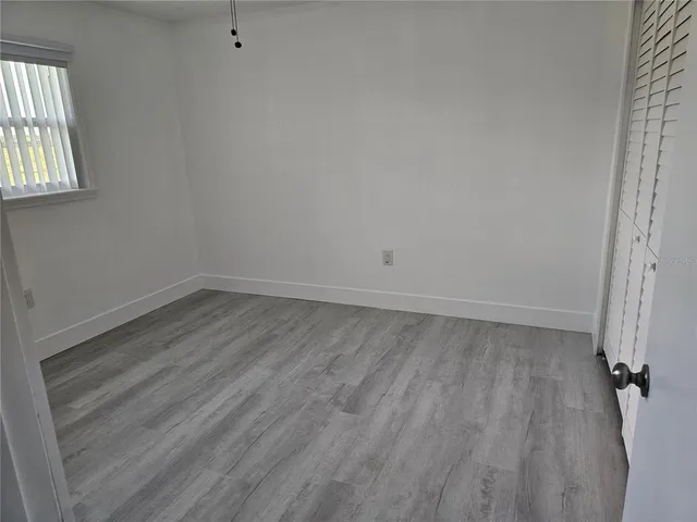 a view of a room that has wooden floor and window