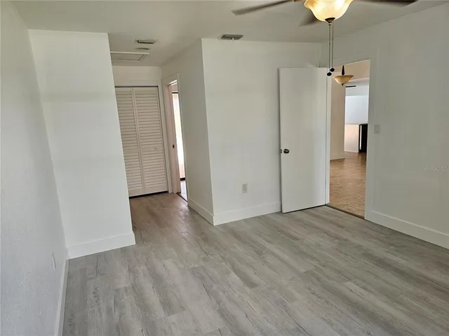a view of empty room with wooden floor