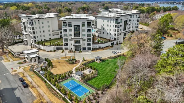 an aerial view of residential houses with outdoor space and parking