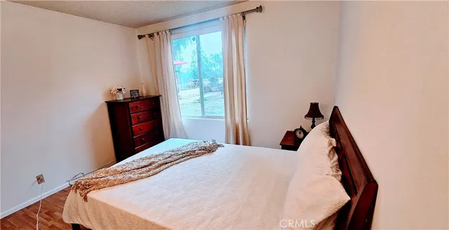 a bedroom with a bed and wooden floor