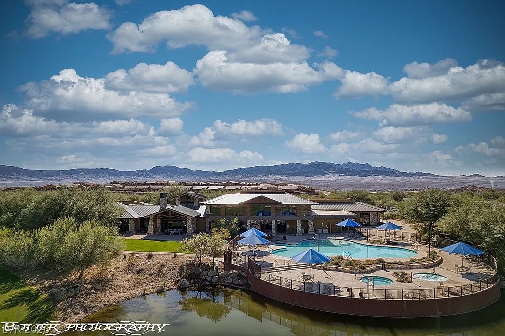 1304 Cottage Ridge Mesquite, NV 89034 - Photo 51 of 52 A desert oasis, this property features a clubhouse, inviting pool, and tranquil pond amidst a mountain backdrop.