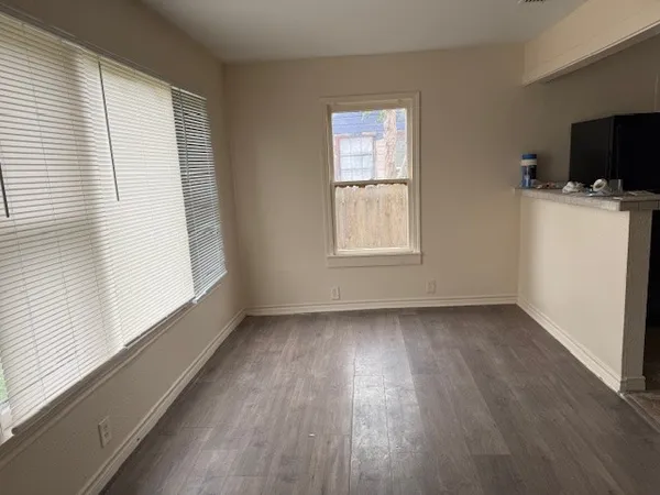 a view of a room with wooden floor and a window