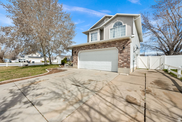 1284 North 900 West Clinton, UT 84015 - Photo 2 of 22 View of front facade featuring a gate, driveway, an attached garage, and brick siding