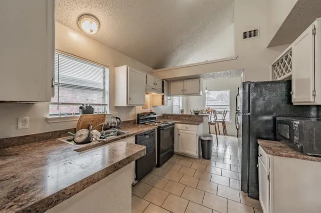 a kitchen with refrigerator and cabinets