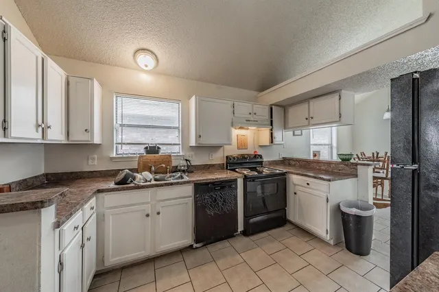 a kitchen with stainless steel appliances granite countertop a sink stove refrigerator and cabinets