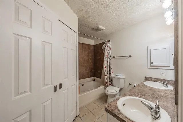 a bathroom with a granite countertop toilet sink and mirror