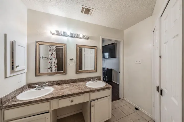 a bathroom with a granite countertop sink a mirror and a shower