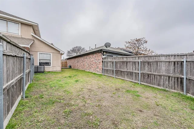 a view of a backyard with wooden fence