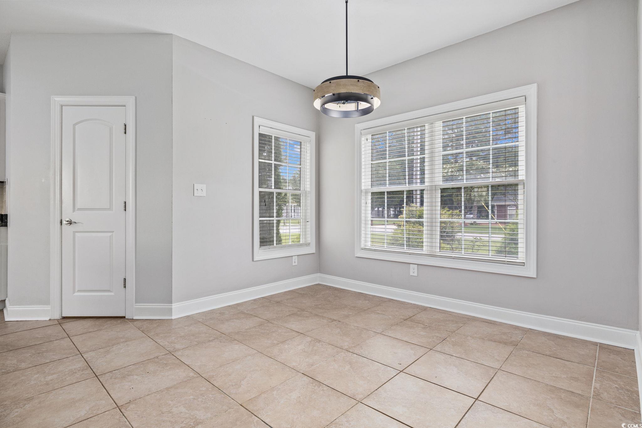 11569 Bay Drive Little River, SC 29566 - Photo 11 of 40 Unfurnished dining area featuring baseboards and light tile patterned floors