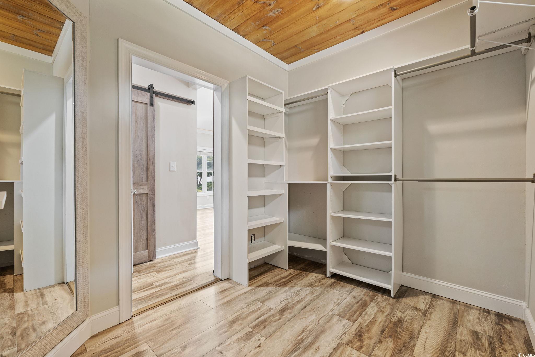 11569 Bay Drive Little River, SC 29566 - Photo 18 of 40 Spacious closet with a barn door and wood finished floors