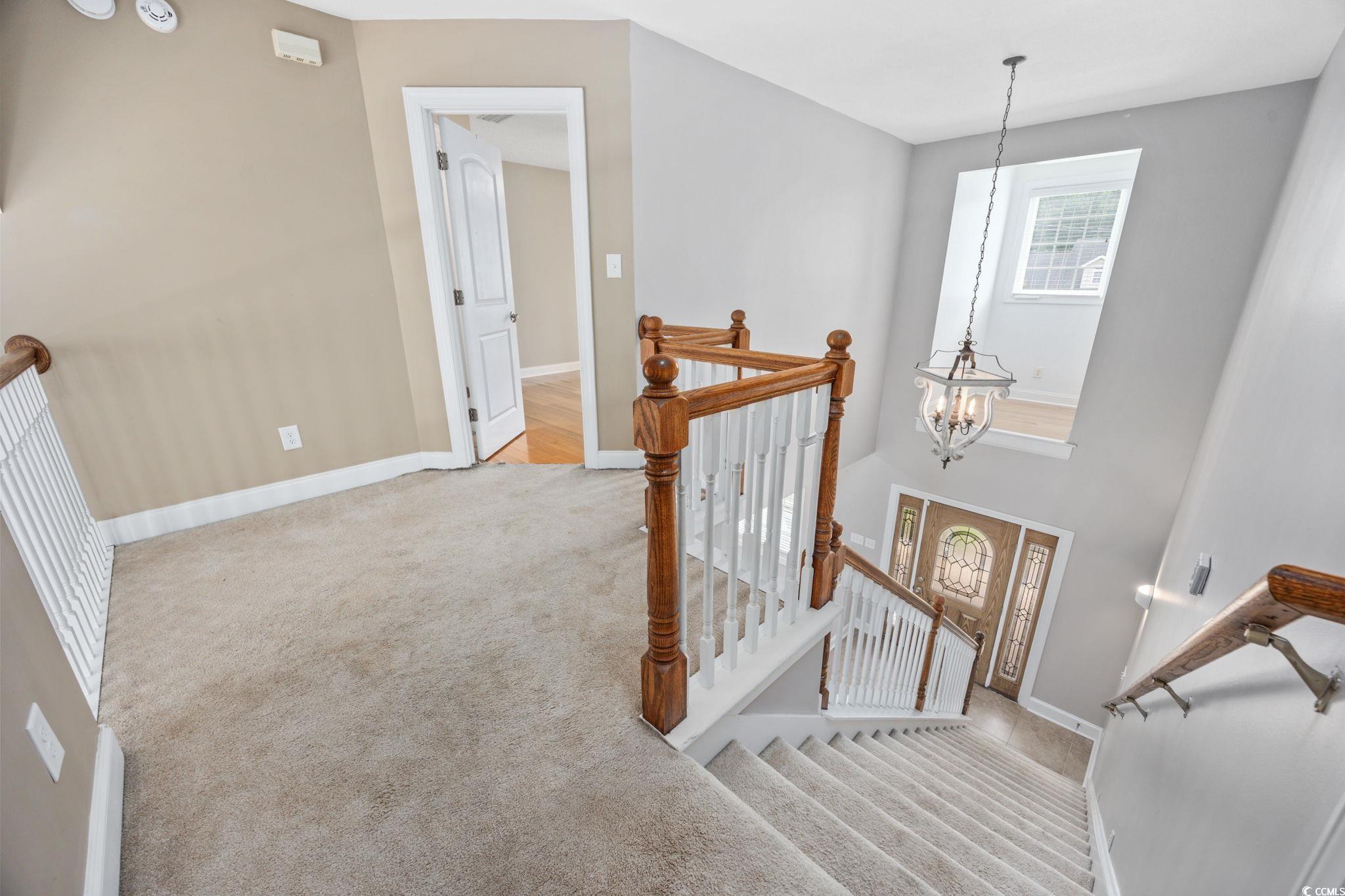 11569 Bay Drive Little River, SC 29566 - Photo 19 of 40 Stairs featuring carpet and a chandelier