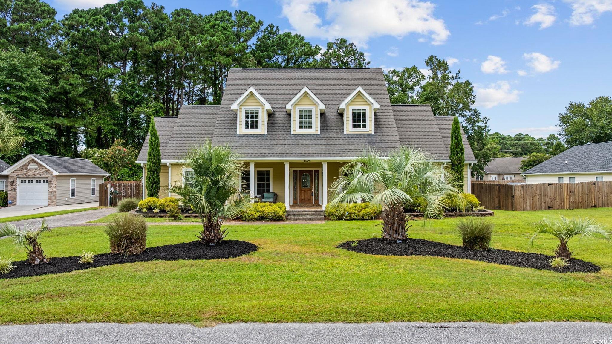 11569 Bay Drive Little River, SC 29566 - Photo 2 of 40 Cape cod-style house featuring covered porch, roof with shingles, and a detached garage
