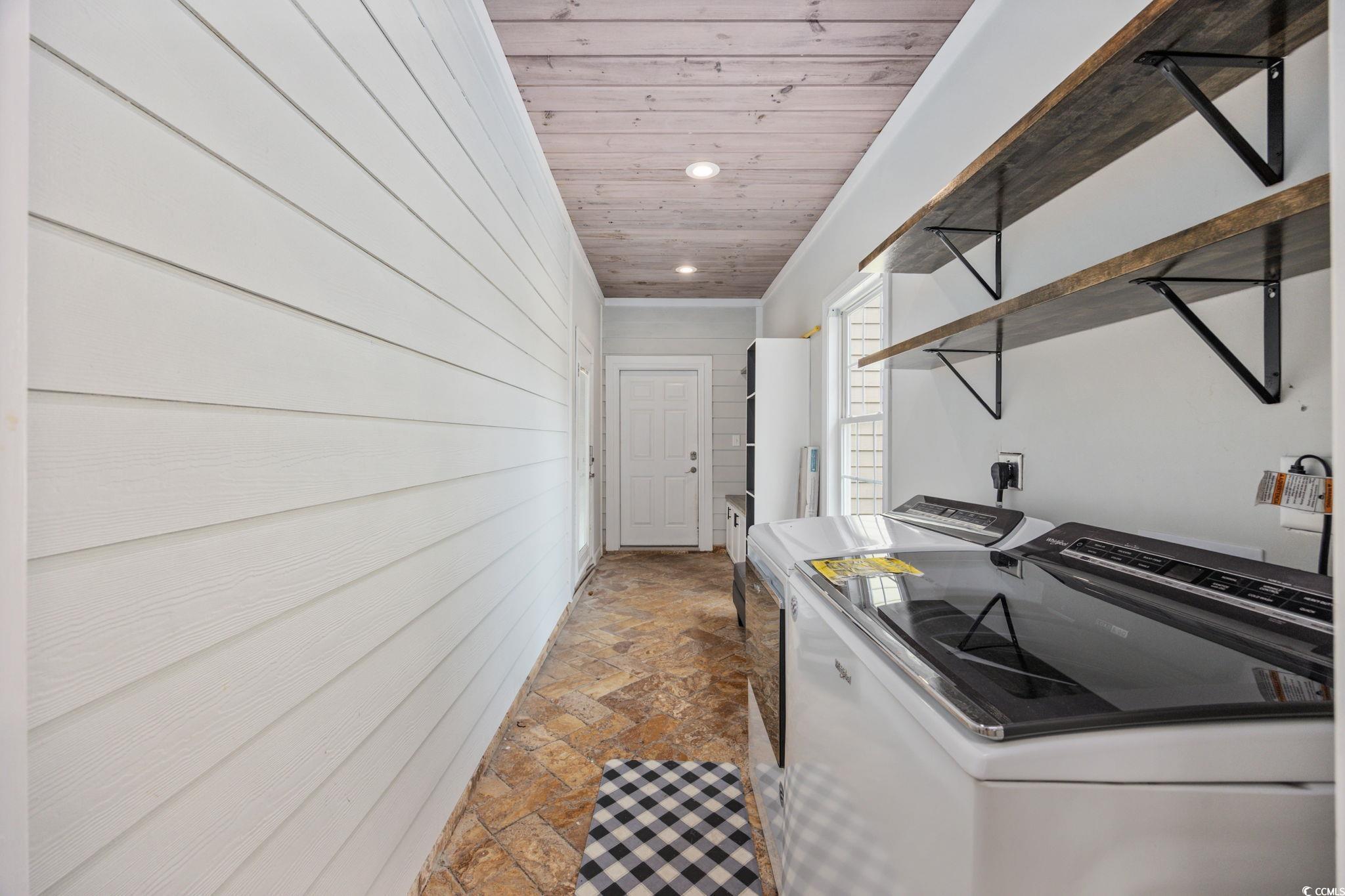 11569 Bay Drive Little River, SC 29566 - Photo 26 of 40 Laundry room with washing machine and clothes dryer, stone finish flooring, wood walls, crown molding, and recessed lighting
