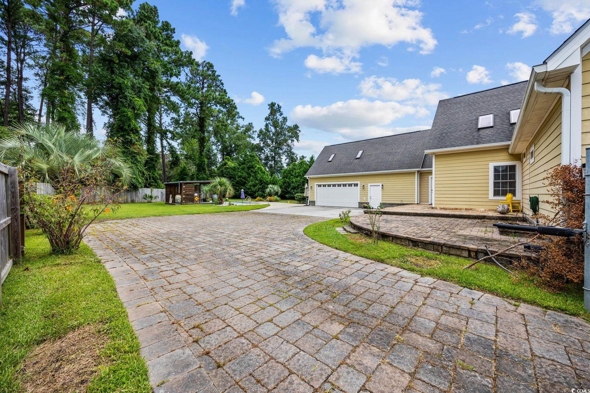 11569 Bay Drive Little River, SC 29566 - Photo 33 of 40 View of yard with decorative driveway and an attached garage