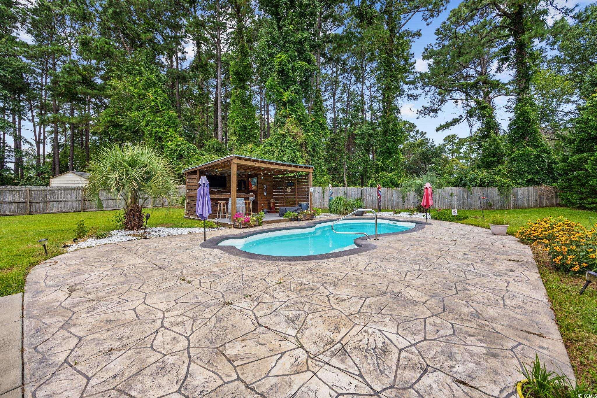 11569 Bay Drive Little River, SC 29566 - Photo 36 of 40 View of swimming pool with a patio area, a fenced backyard, an outdoor structure, and an exterior structure
