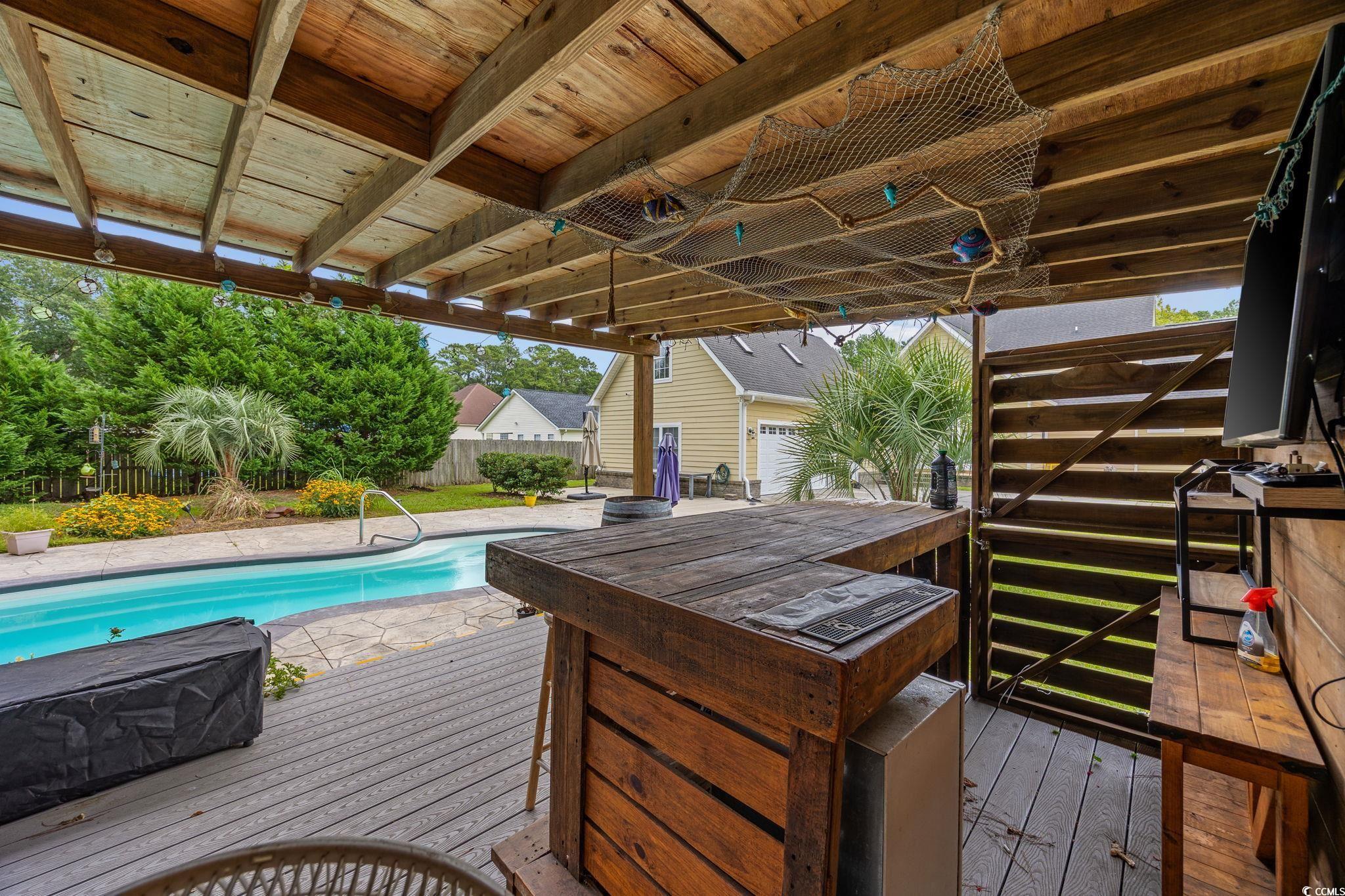 11569 Bay Drive Little River, SC 29566 - Photo 38 of 40 Deck featuring an outdoor pool and a fenced backyard
