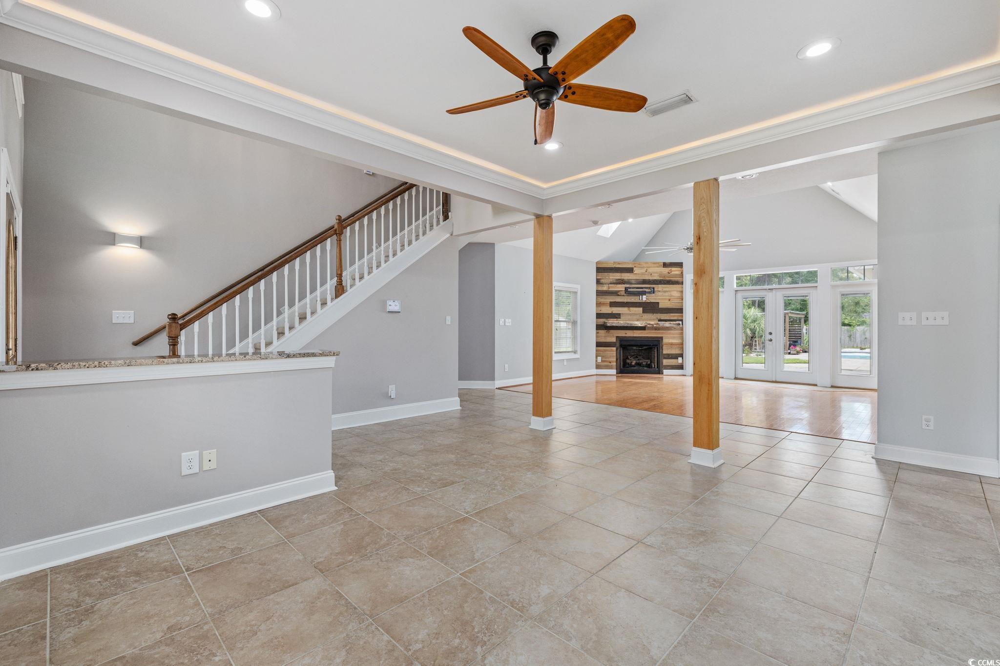 11569 Bay Drive Little River, SC 29566 - Photo 6 of 40 Unfurnished living room with crown molding, ceiling fan, a fireplace, light tile patterned flooring, and recessed lighting