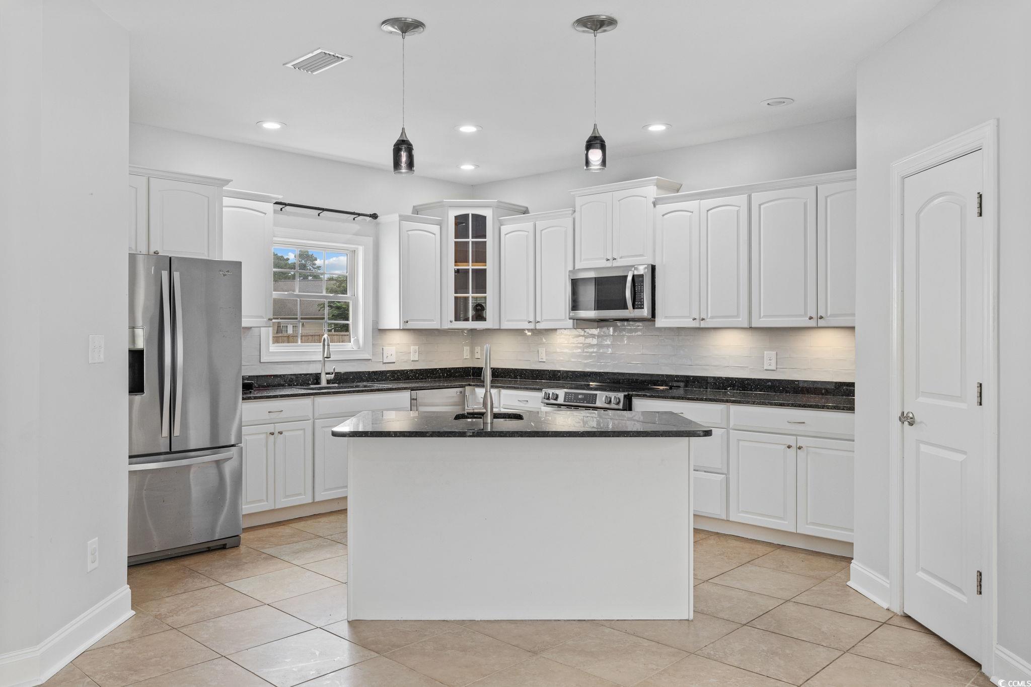 11569 Bay Drive Little River, SC 29566 - Photo 9 of 40 Kitchen with stainless steel appliances, white cabinets, light tile patterned floors, hanging light fixtures, and recessed lighting