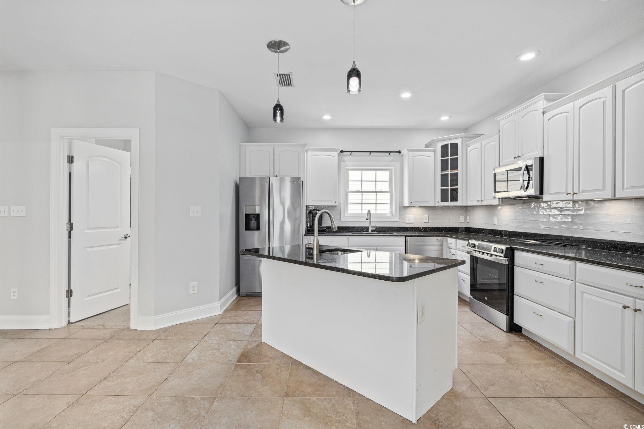 11569 Bay Drive Little River, SC 29566 - Photo 10 of 40 Kitchen with appliances with stainless steel finishes, backsplash, white cabinetry, pendant lighting, and recessed lighting