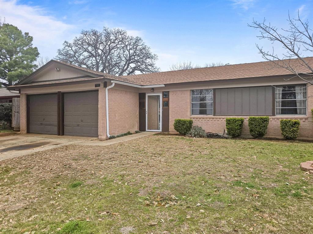 Single story home with roof with shingles, an attached garage, driveway, and a front yard