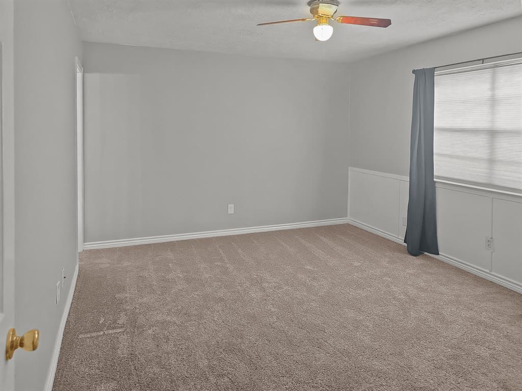 701 Idlewilde Drive Lewisville, TX 75067 - Photo 4 of 13 Primary bedroom featuring a ceiling fan, new carpet and a textured ceiling