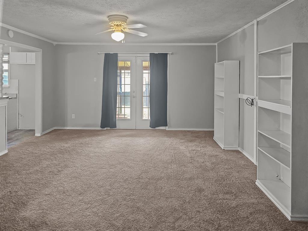 701 Idlewilde Drive Lewisville, TX 75067 - Photo 10 of 13 Living room with new carpet, updated shelving and French doors to covered patio