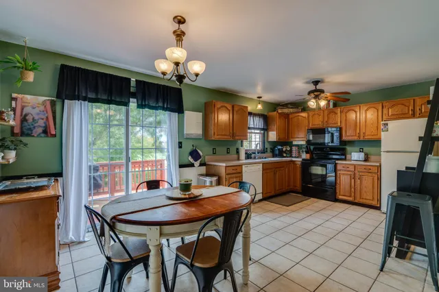 a kitchen with a table chairs refrigerator and microwave