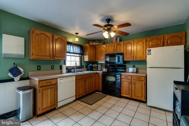 a kitchen with stainless steel appliances granite countertop a refrigerator a sink dishwasher a stove with chairs and island