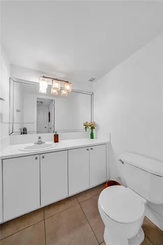 a spacious bathroom with a toilet a sink and mirror