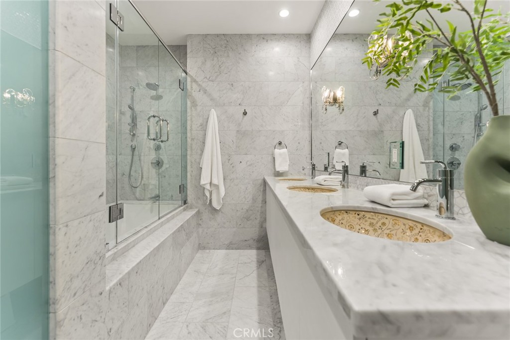 11765 Riehl Avenue Tustin, CA 92782 - Photo 42 of 53 a bathroom with a granite countertop sink a mirror a bathtub and shower