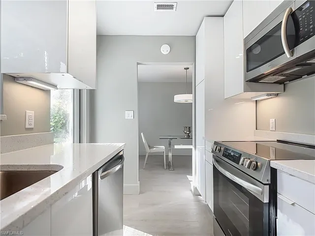 a kitchen with stainless steel appliances granite countertop a sink a stove and a refrigerator