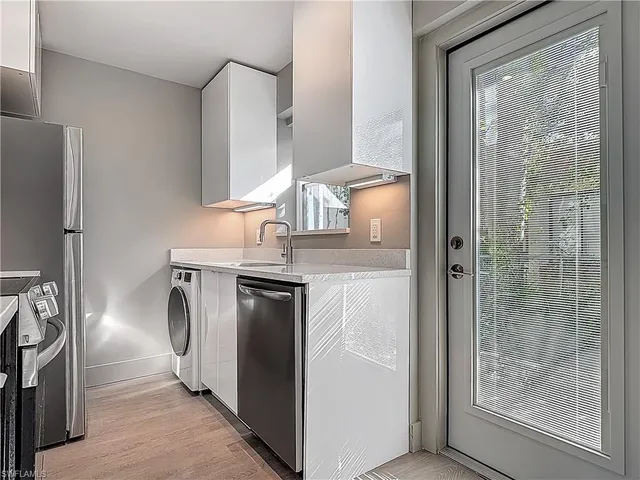 a kitchen with kitchen island wooden cabinets and refrigerator