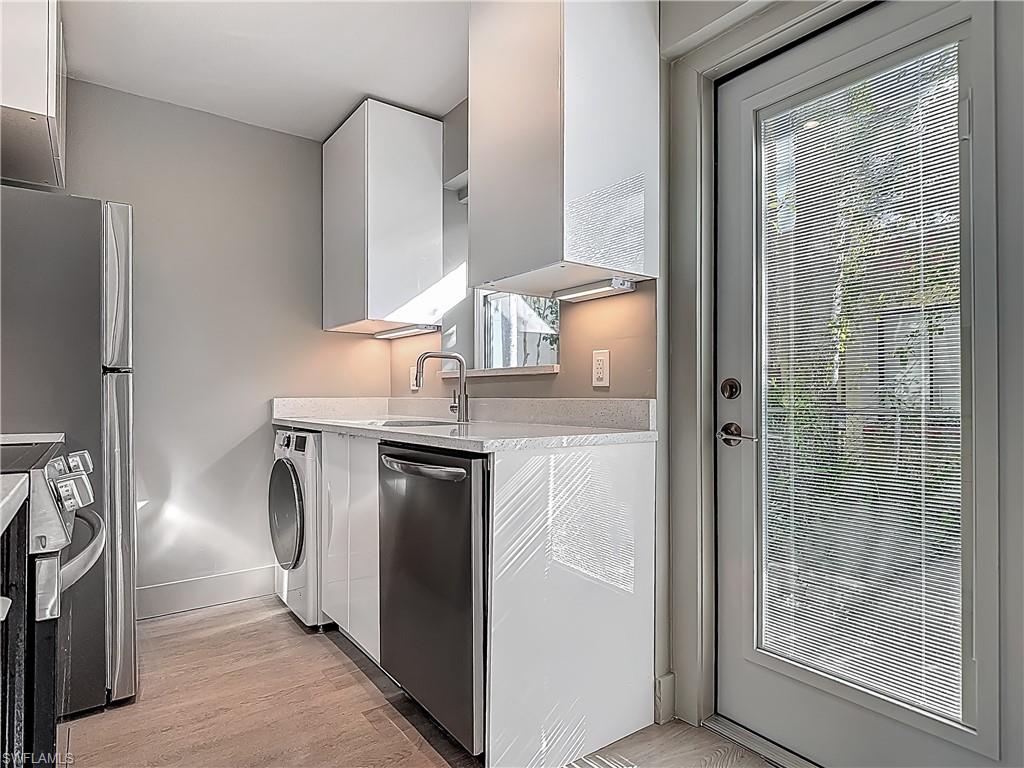 2544 First Street, Unit 102 Fort Myers, FL 33901 - Photo 7 of 19 a kitchen with kitchen island wooden cabinets and refrigerator