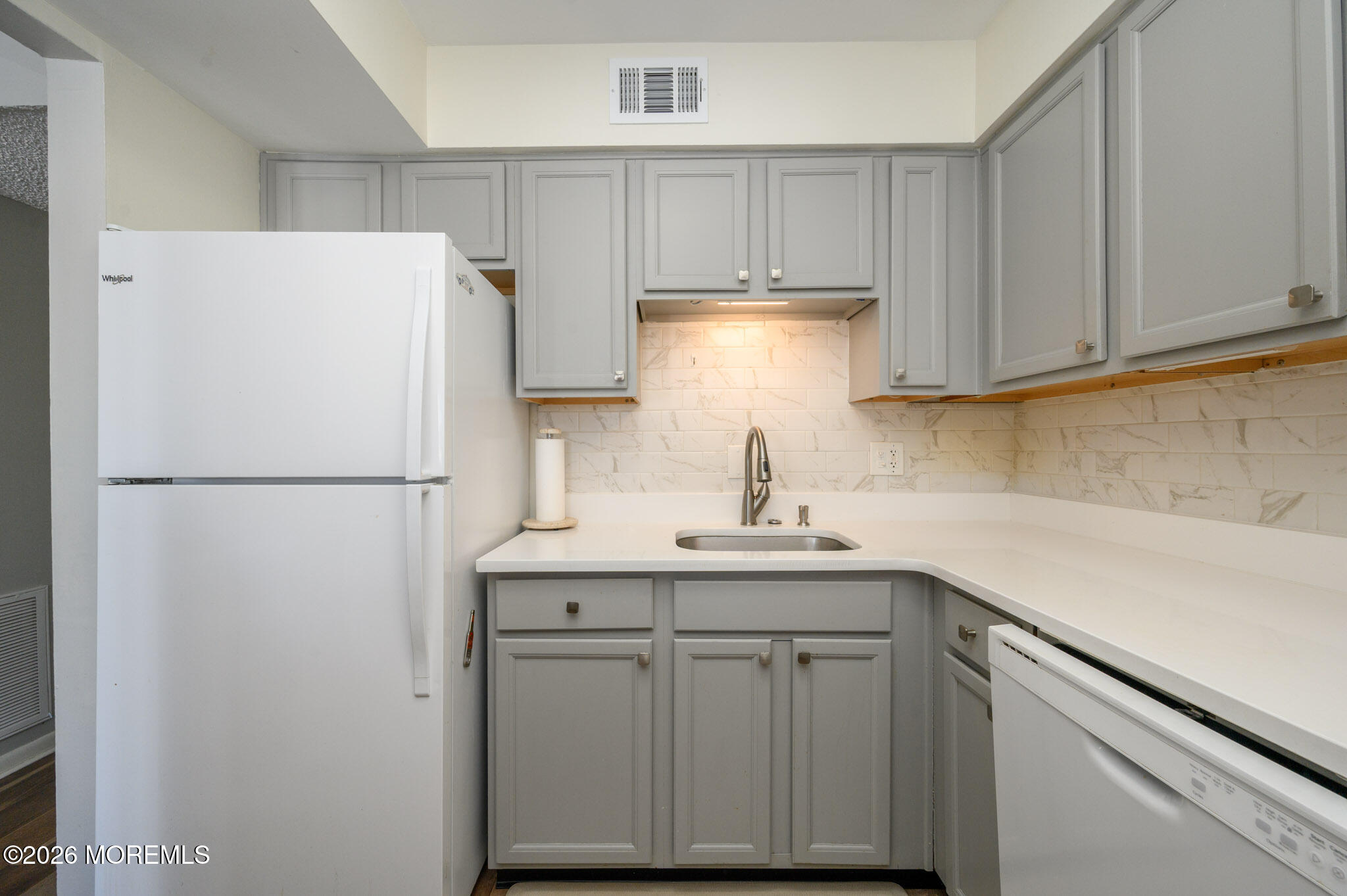 17 Inwood Terrace Freehold, NJ 07728 - Photo 11 of 22 a kitchen with a sink a refrigerator and cabinets