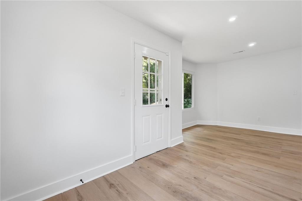 1808 Singer Way Lithonia, GA 30058 - Photo 13 of 37 an empty room with wooden floor and windows
