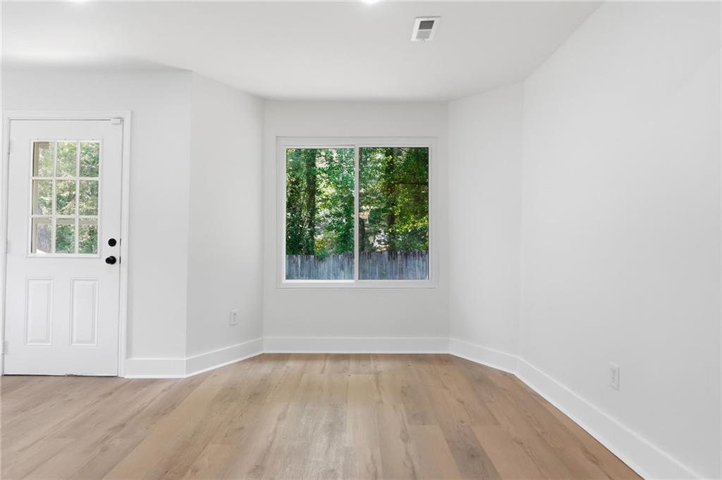 1808 Singer Way Lithonia, GA 30058 - Photo 15 of 37 an empty room with wooden floor and windows