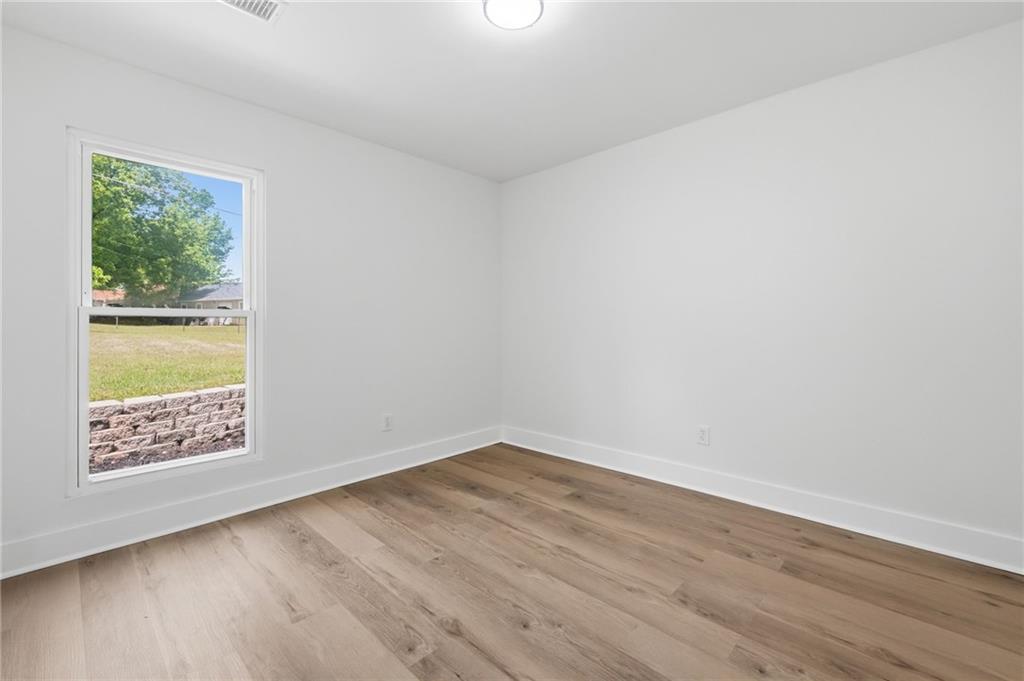 1808 Singer Way Lithonia, GA 30058 - Photo 19 of 37 an empty room with wooden floor and windows
