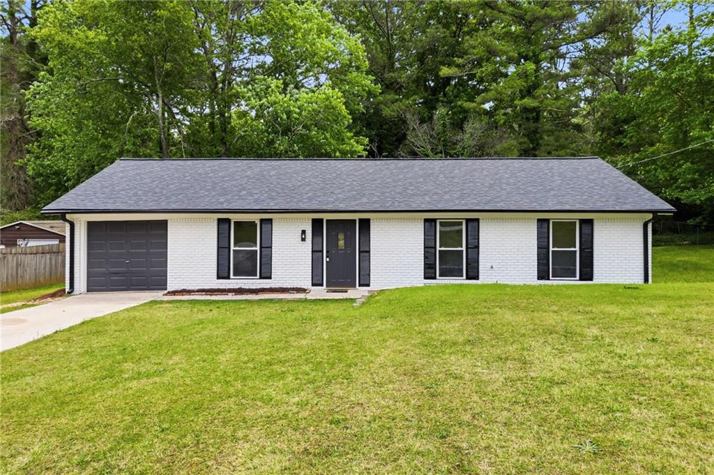 1808 Singer Way Lithonia, GA 30058 - Photo 2 of 37 a view of a yard in front of a house with a large tree