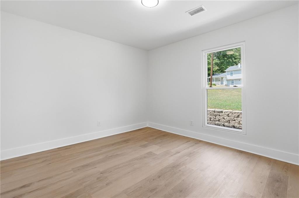 1808 Singer Way Lithonia, GA 30058 - Photo 21 of 37 an empty room with wooden floor and windows