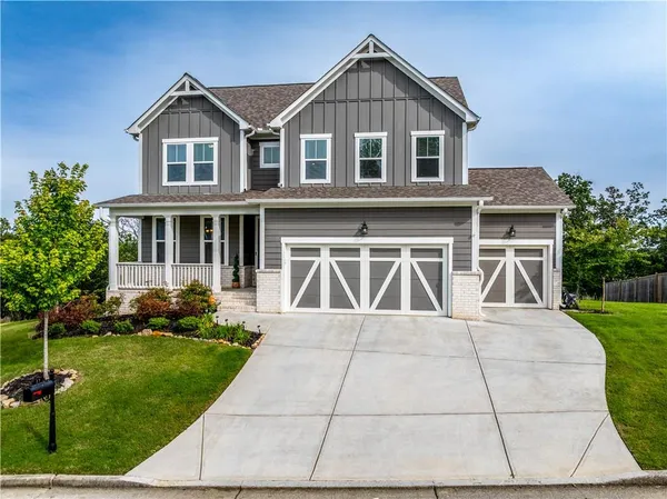 a front view of a house with a yard and potted plants