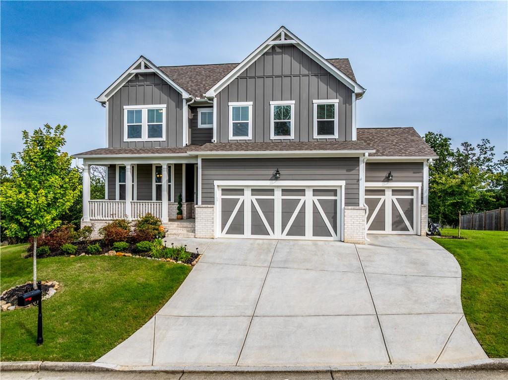 a front view of a house with a yard and potted plants