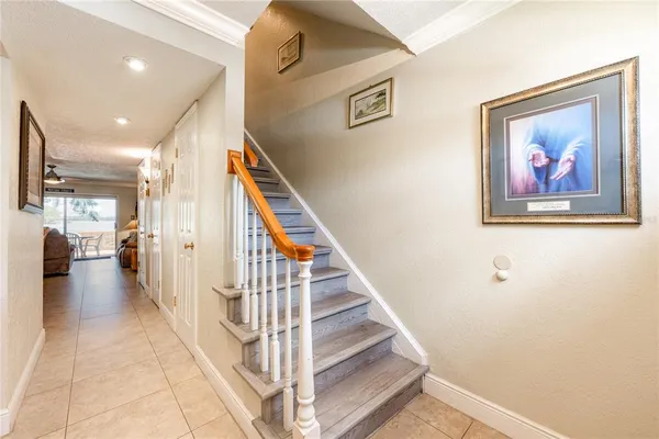a view of staircase with lots of frames on wall and a view of a hallway