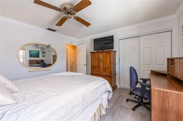 a bedroom with a bed a flat screen tv and a book shelf