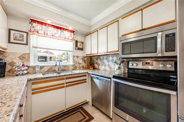 a kitchen with appliances a sink and cabinets