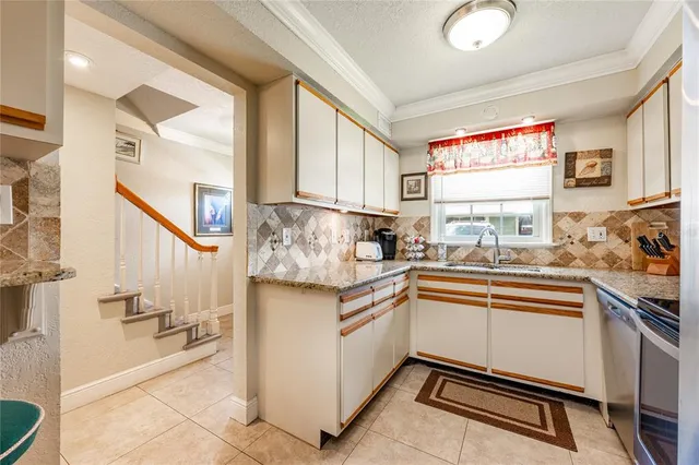 a room with stainless steel appliances kitchen island granite countertop furniture and a view of living room